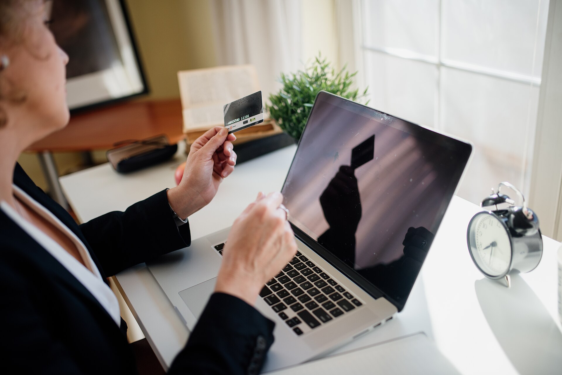 Người dùng đối chiếu lãi suất khoản vay và thẻ tín dụng trên laptop